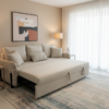 Le Marche Offer "25 Beige Dream sectional sofa bed in a living room with a lamp, side table, and abstract art on the wall.